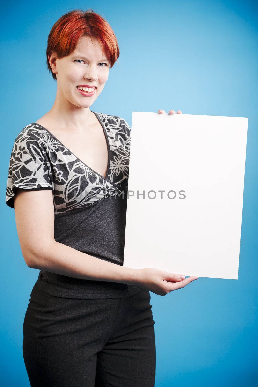 Read head woman holding a empty note against blue background