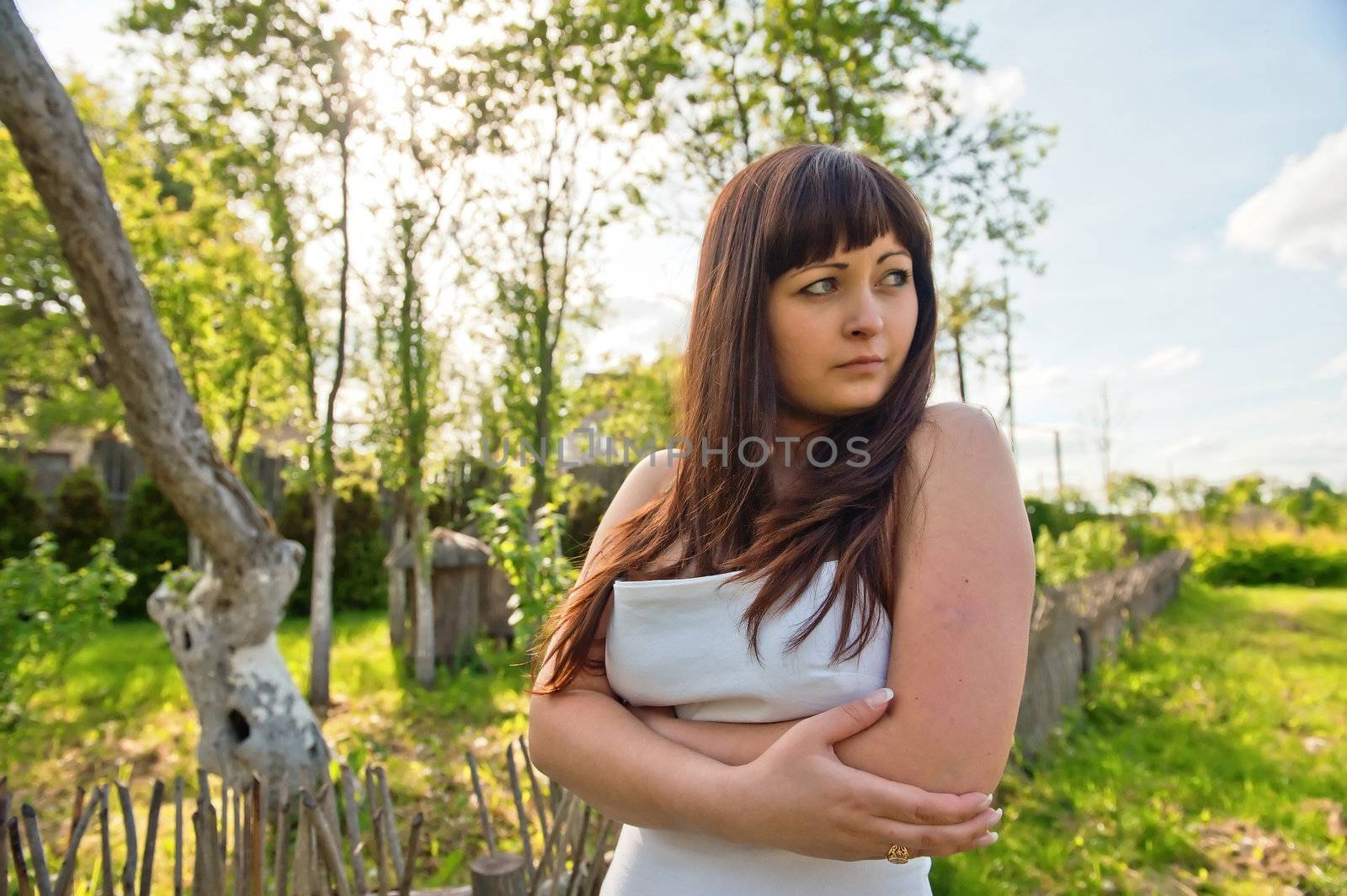 Young, beautiful woman stand in farmstead.
