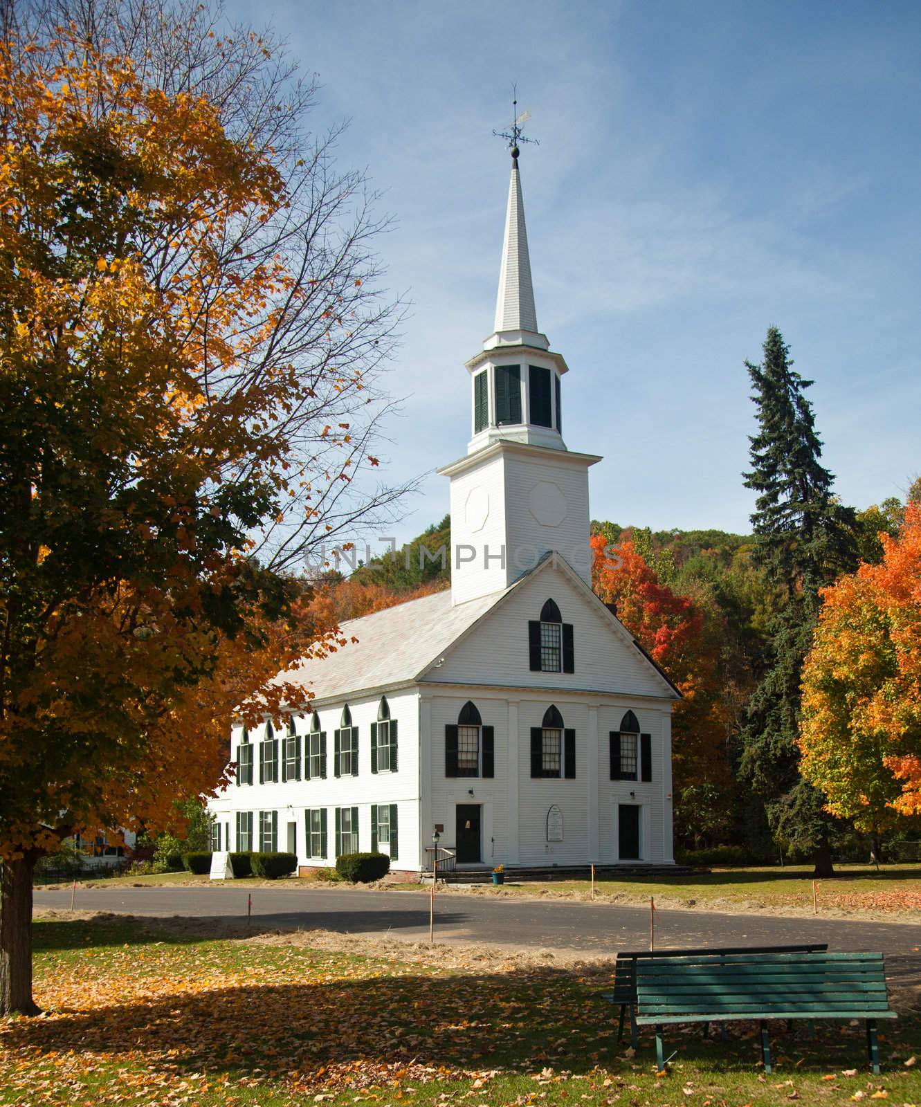 Autumnal shot of the typical Vermont church in fall as the bright trees turn orange and red