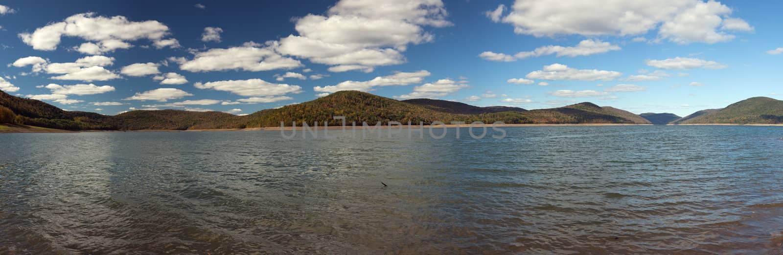 Panorama of autumn scene at Cannonsville Reservoir in New York as leaves are reflected in calm river