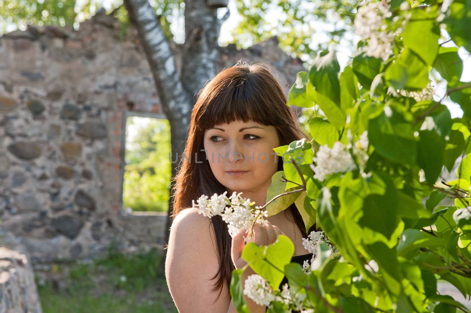 Portrait of young beautiful woman with pipe-tree and ruins on the background.

