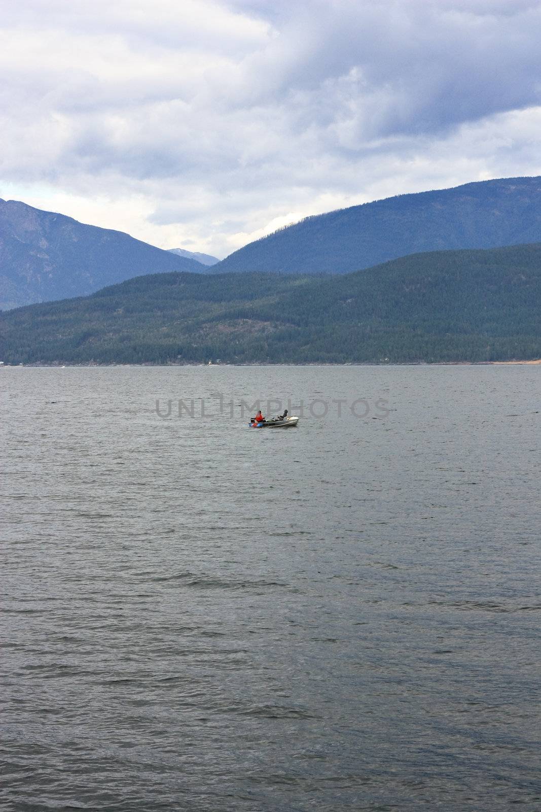 two men in a boat in the middle of the lake