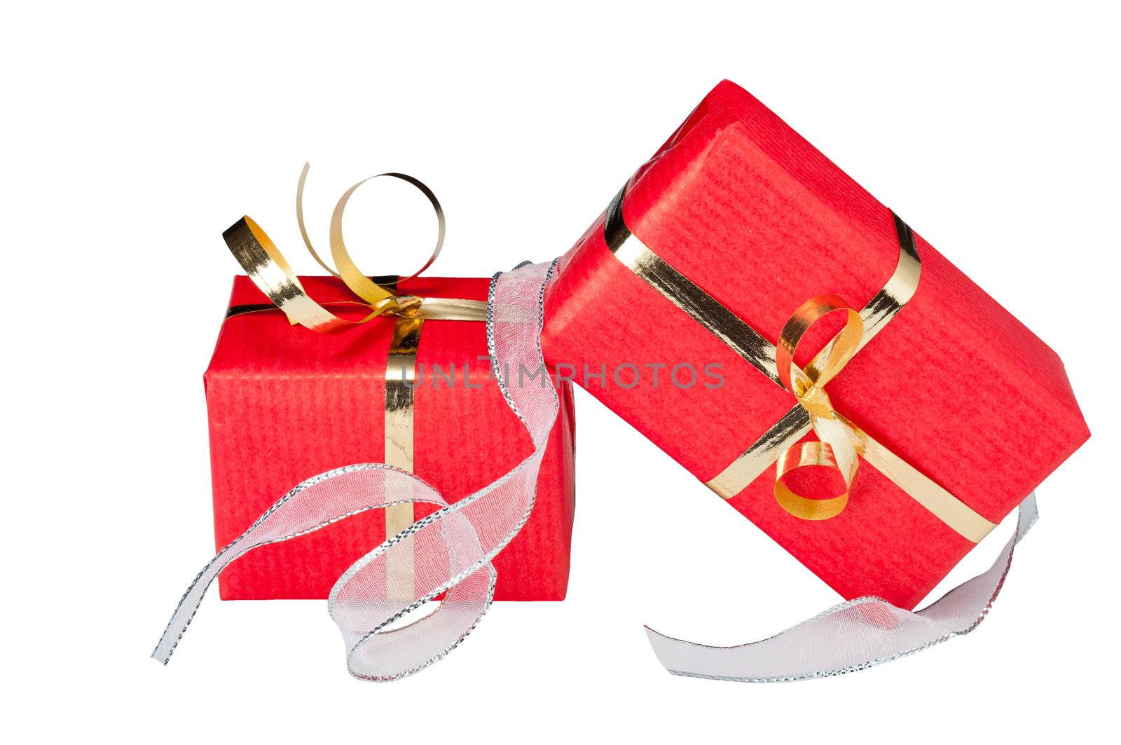 Two red and gold gift boxes with a flowing silver ribbon, isolated on white