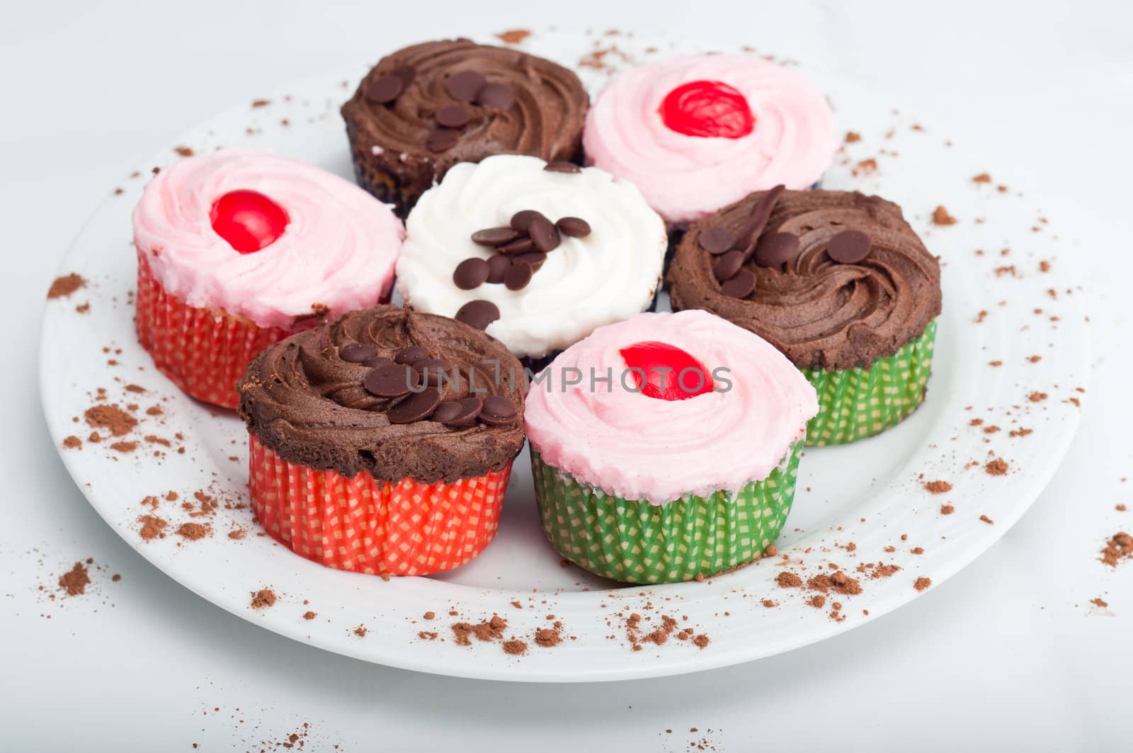 Colorful, delicious cupcakes on a white plate decorated with cinnamon sprinkles