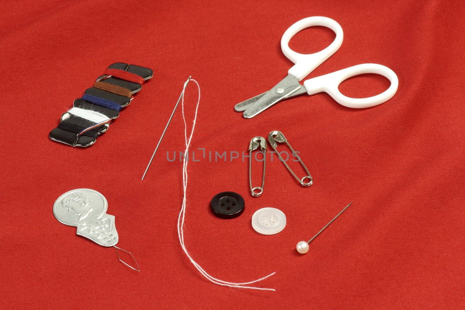 Different sewing utensils over red background