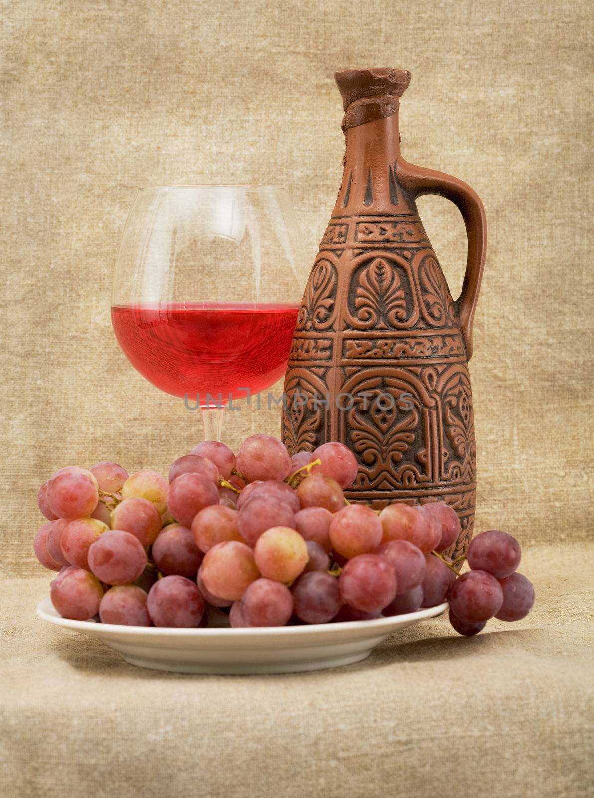 Bright still life with grapes and wine on sacking background