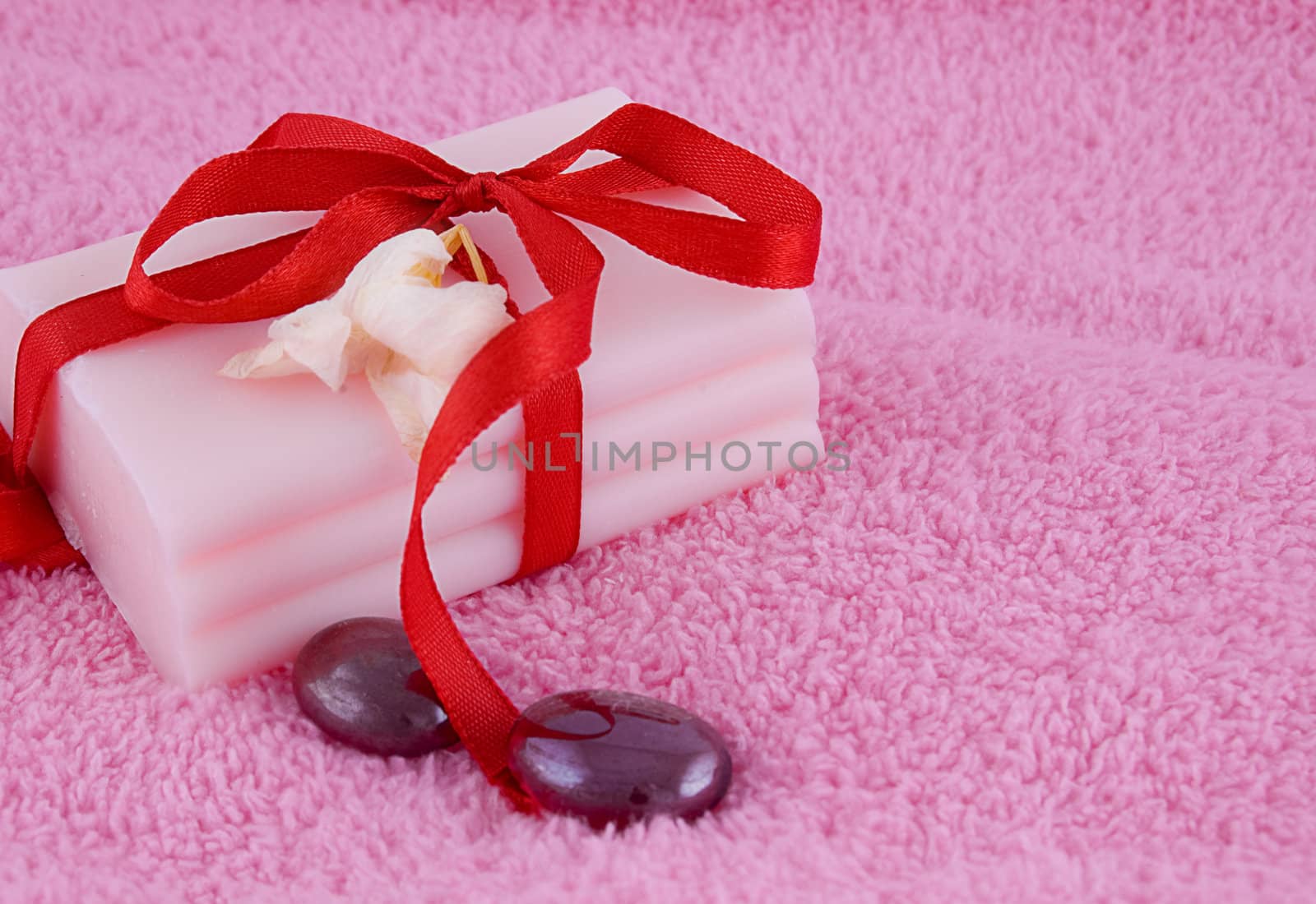 Soap with roses and stones over pink towel