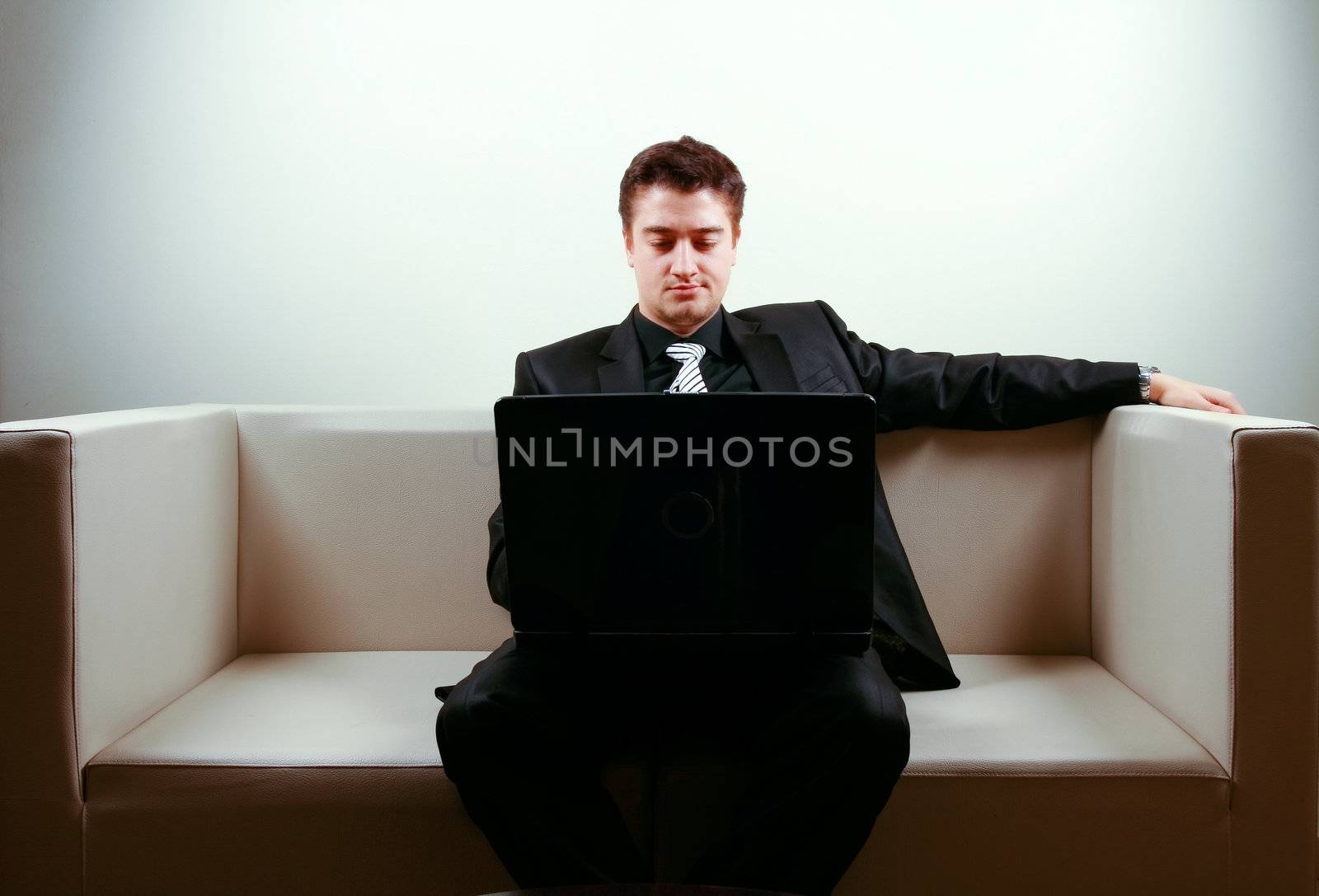 Businessman on lounge holding a laptop