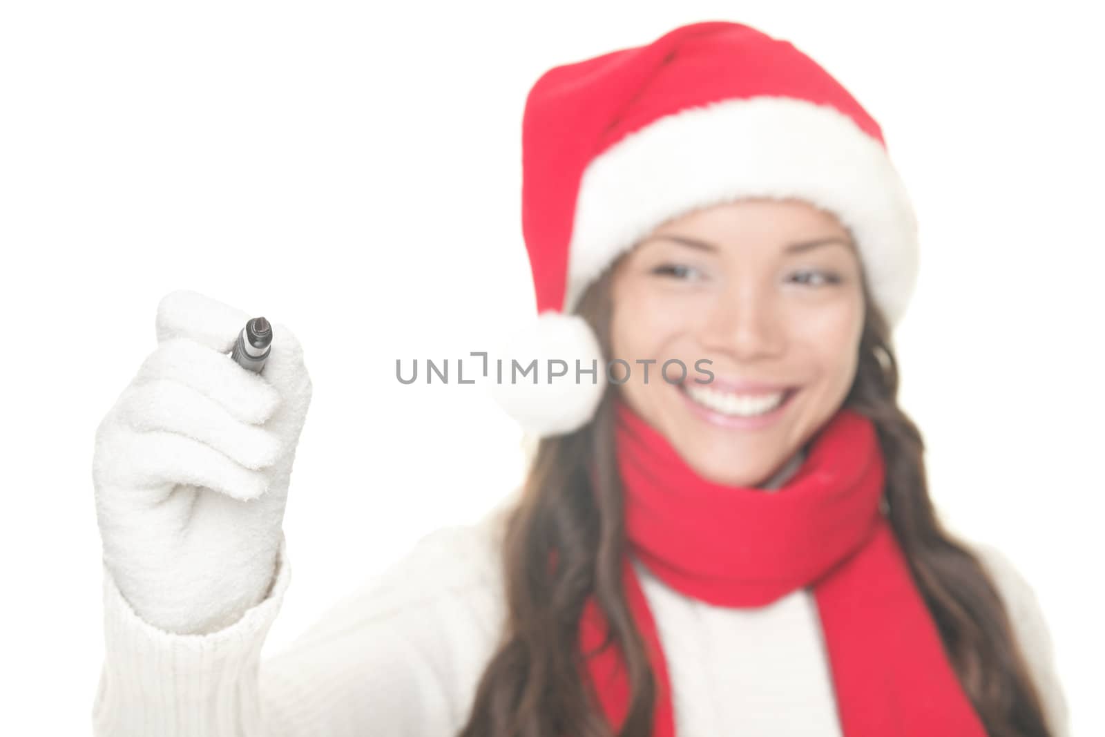Christmas woman writing on screen with copy space for text. Isolated on white background. Asian / Caucasian model in Santa hat and winter sweater.