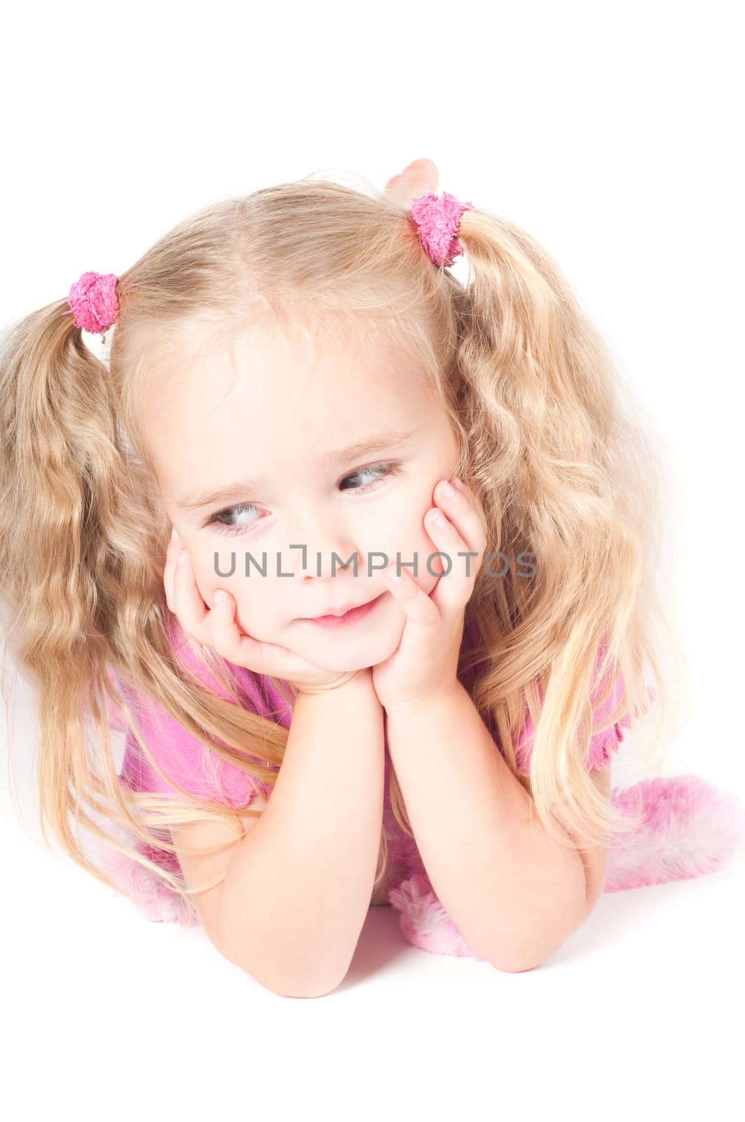 Little cute girl in pink and with ponytails in studio