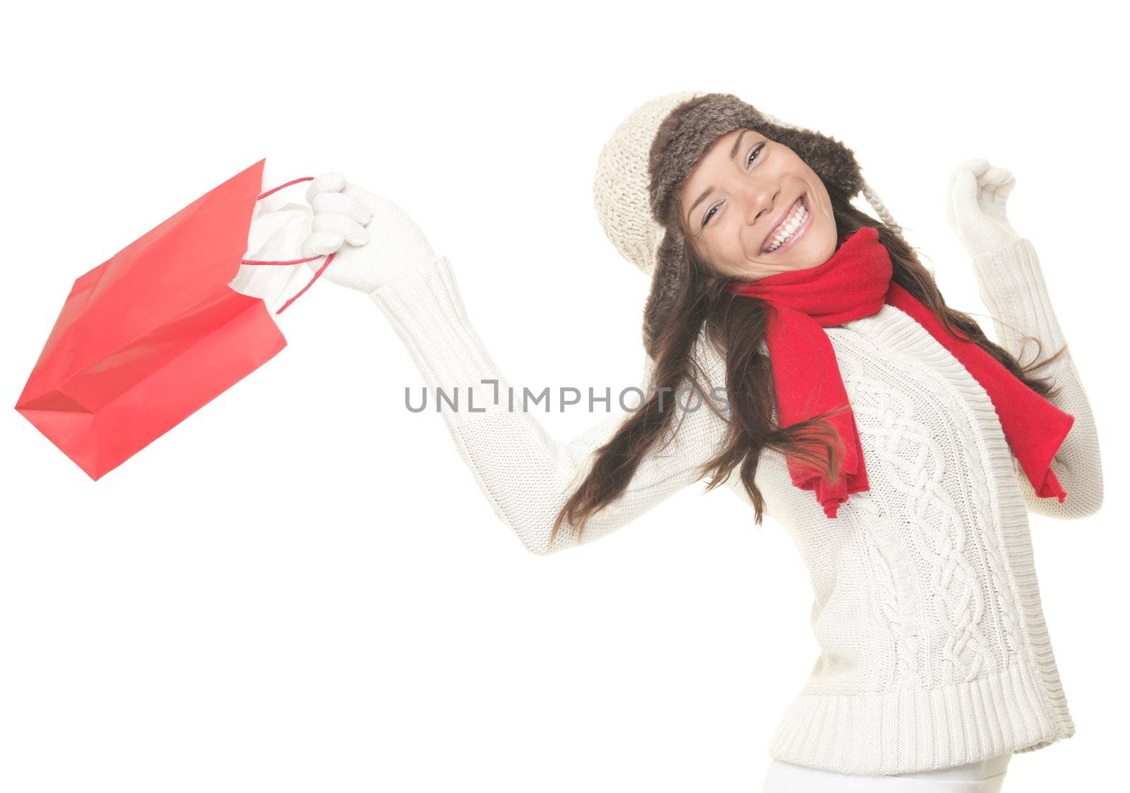 Christmas shopping woman with gift bag running joyful. Smiling young woman in winter clothes holding red shopping bags. Isolated on white background.