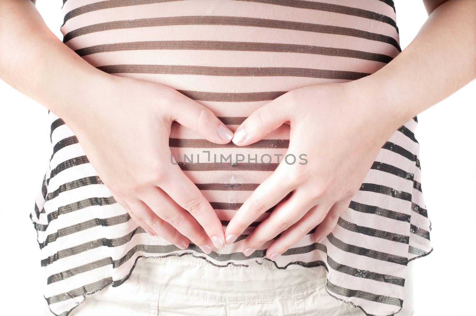 Pregnant woman holding her hands in form of heart sign on her belly