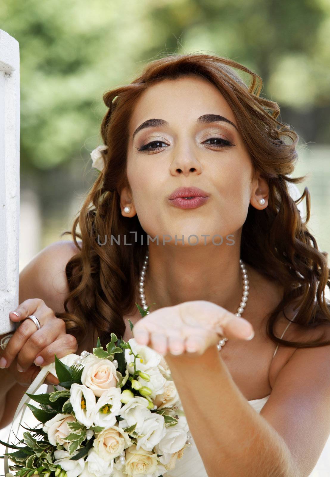 The beautiful bride with bouquet in park