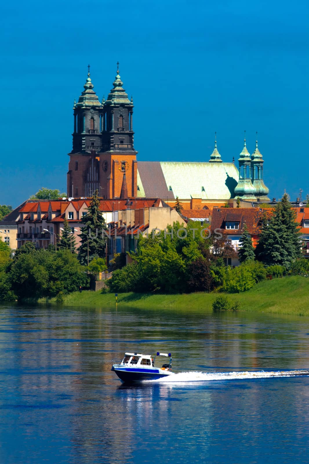 Cathedral church and motorboat at the river in the center of city
