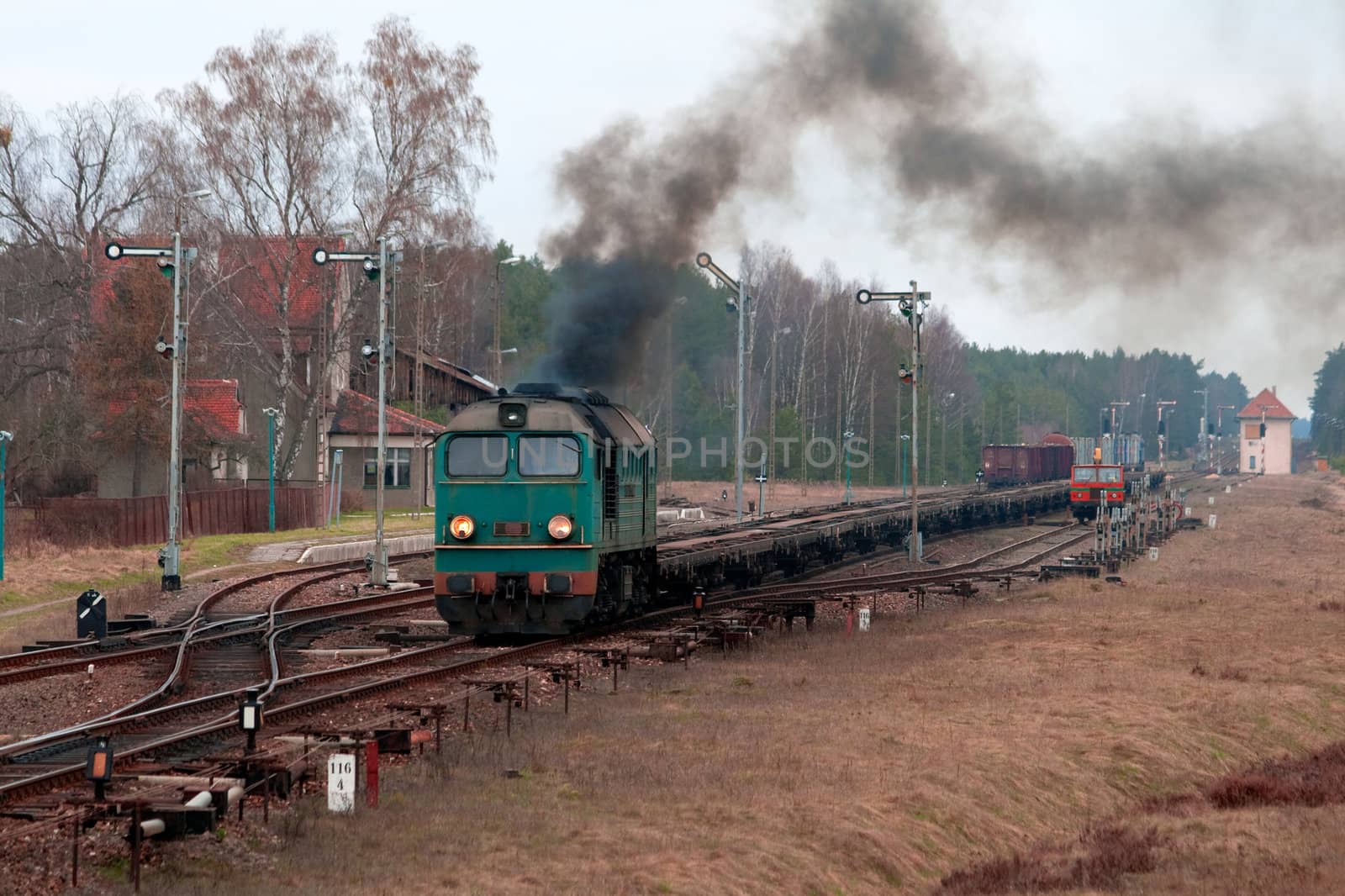 Freight train hauled by the diesel locomotive starting from the station
