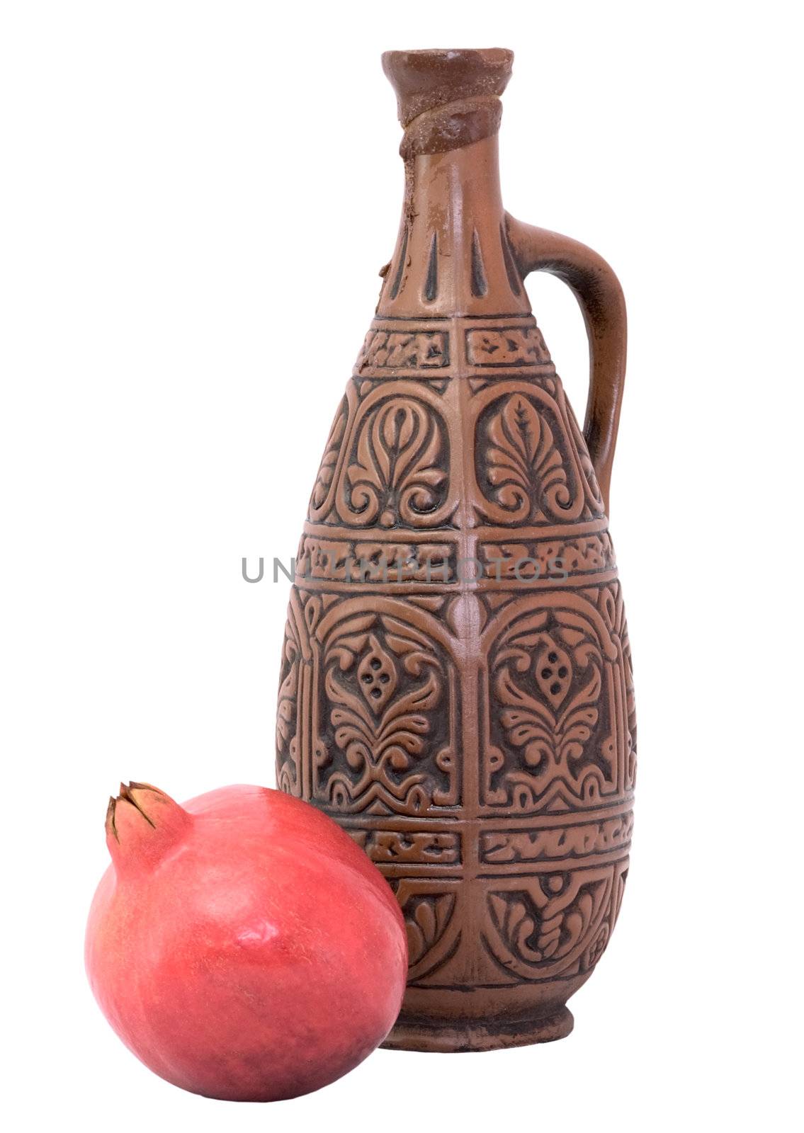 Still-life with a bottle and pomegranate on a white background