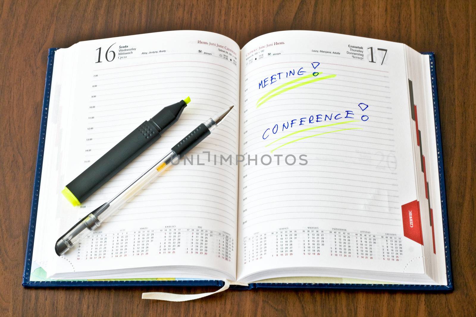 Diary with notes and a marker pen on wooden table
