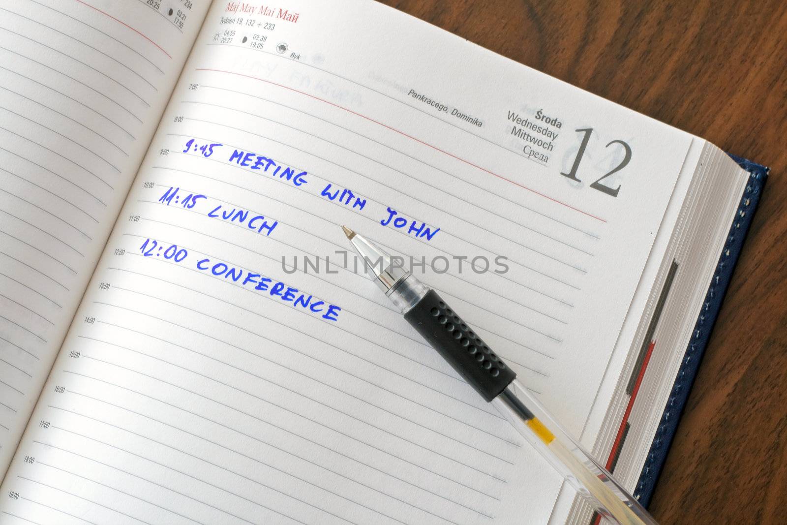 Diary with notes and a pen on wooden table
