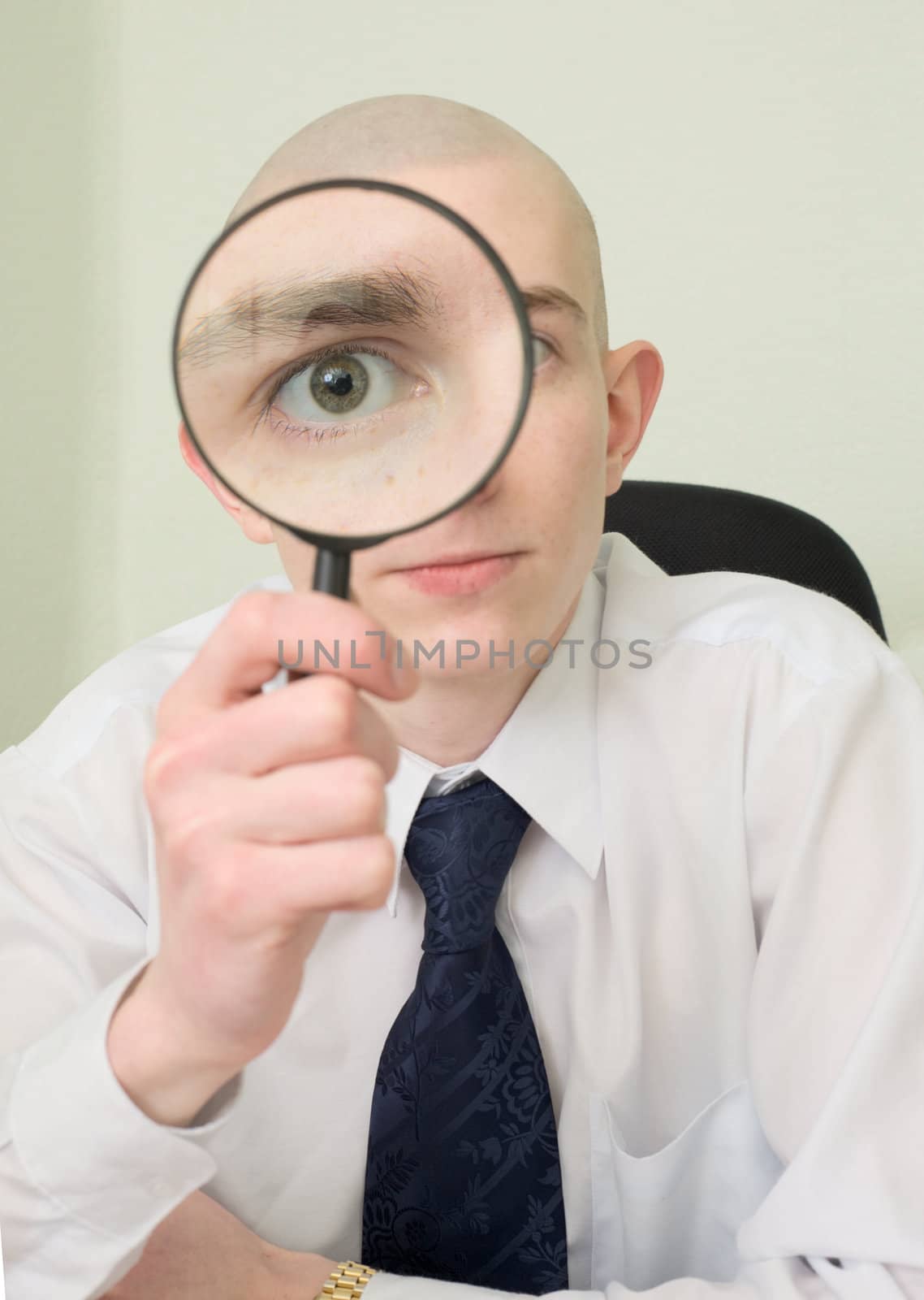 The guy looks through the big magnifier