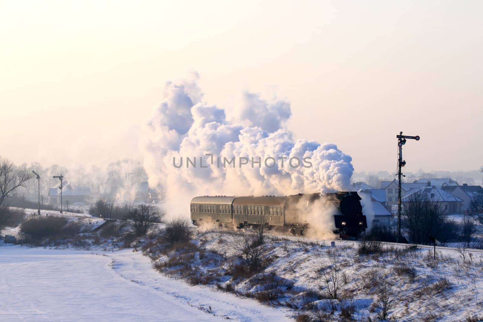 Vintage steam train passing through snowy countryside