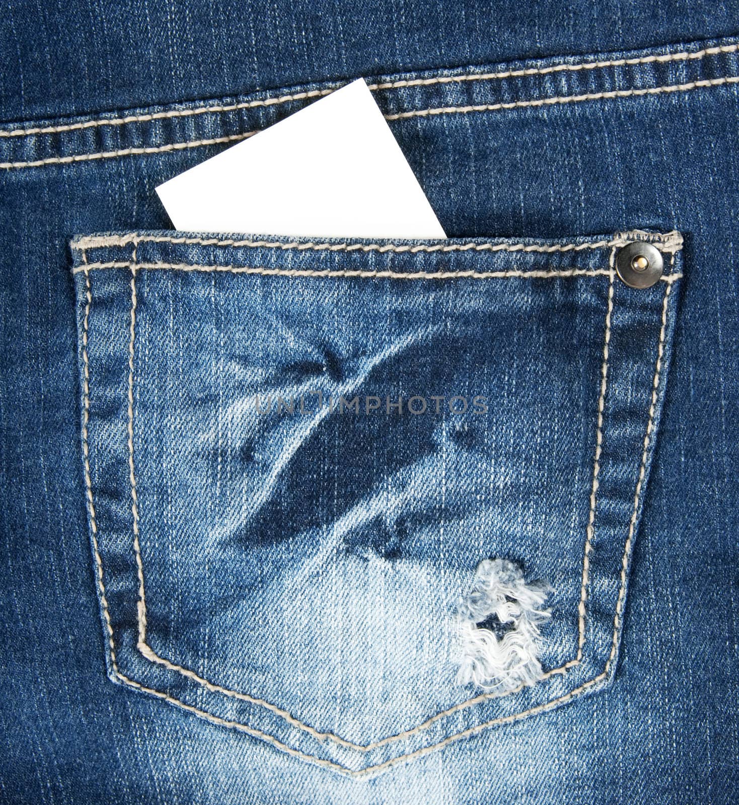 Blank business card with copy space in a pocket of blue worn out jeans.