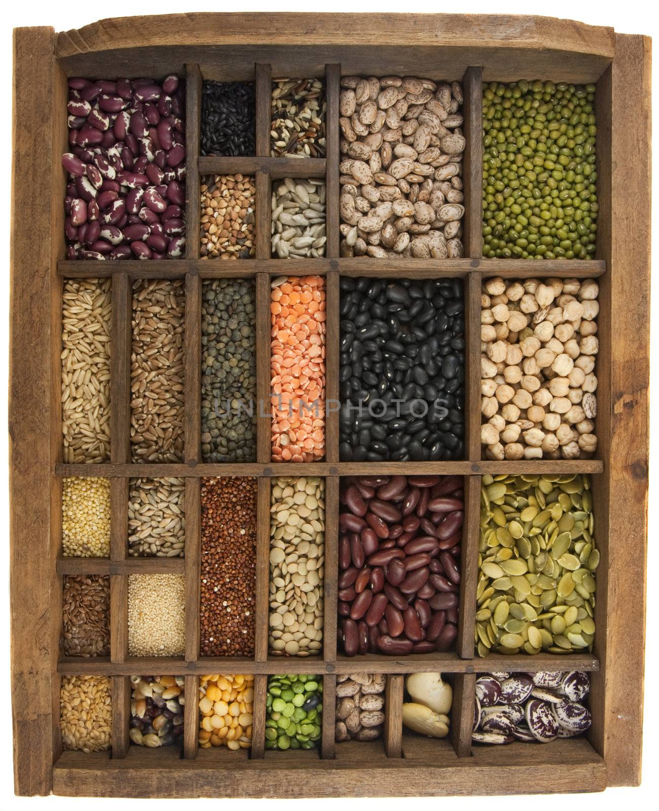 vintage, wooden typesetter case (drawer) with variety of beans, lentils, peas, grains and seeds isolated on white, white angle view