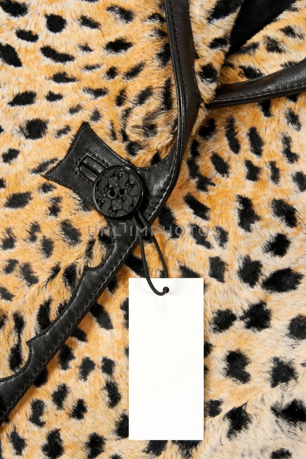 Blank label or price tag attached to a button of a stylish leopard jacket.