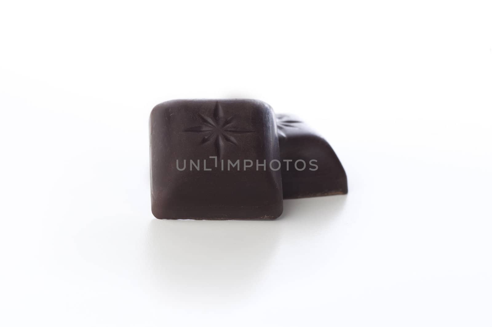 Pieces of dark chocolate isolated on white background.