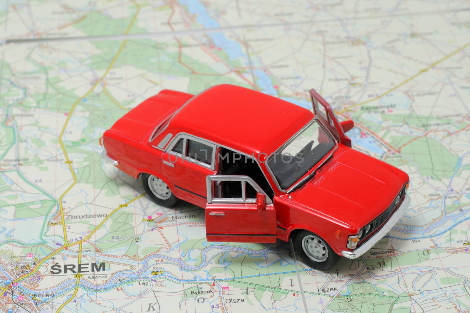 Tiny red car model on the road map