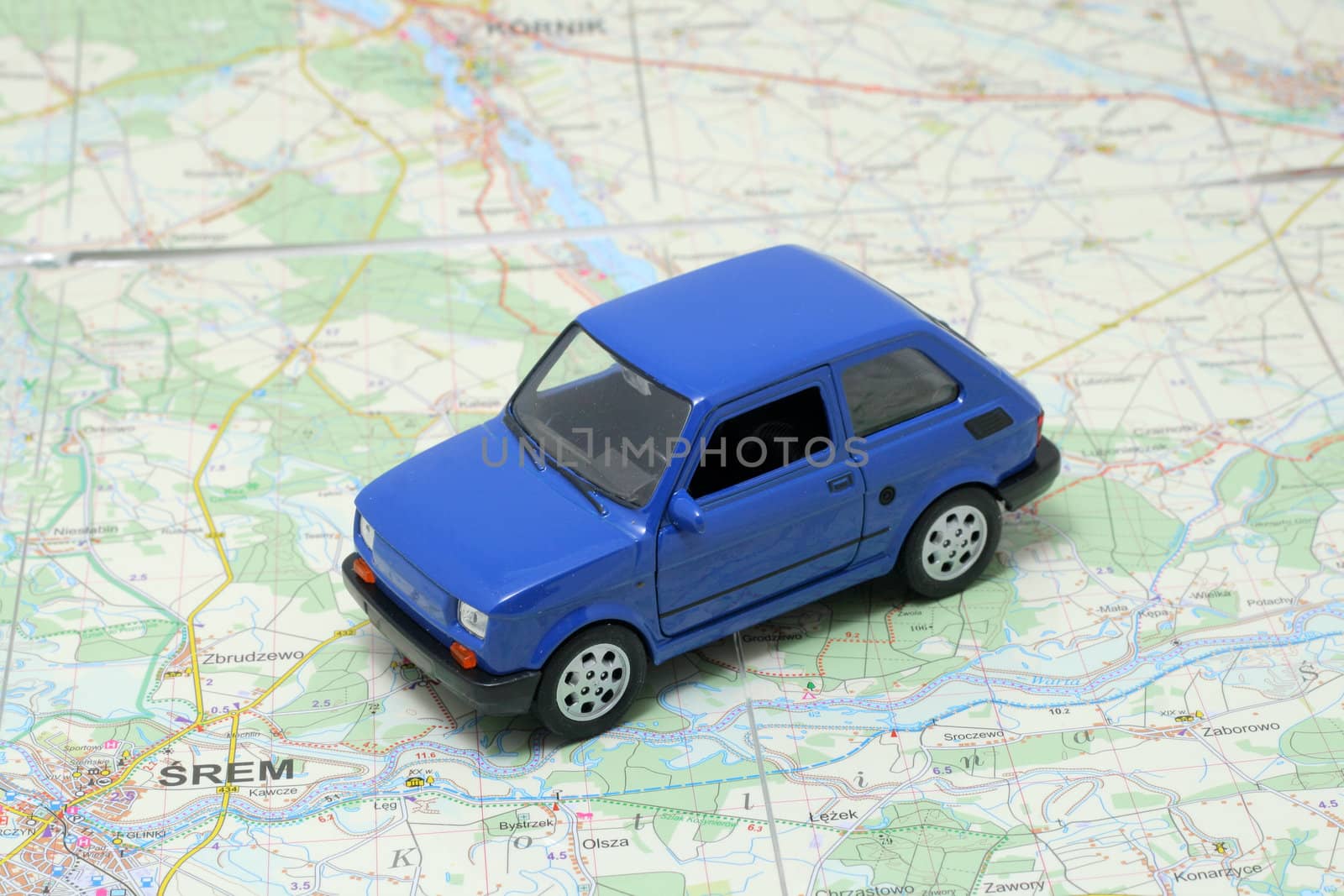 Tiny blue car model on the road map