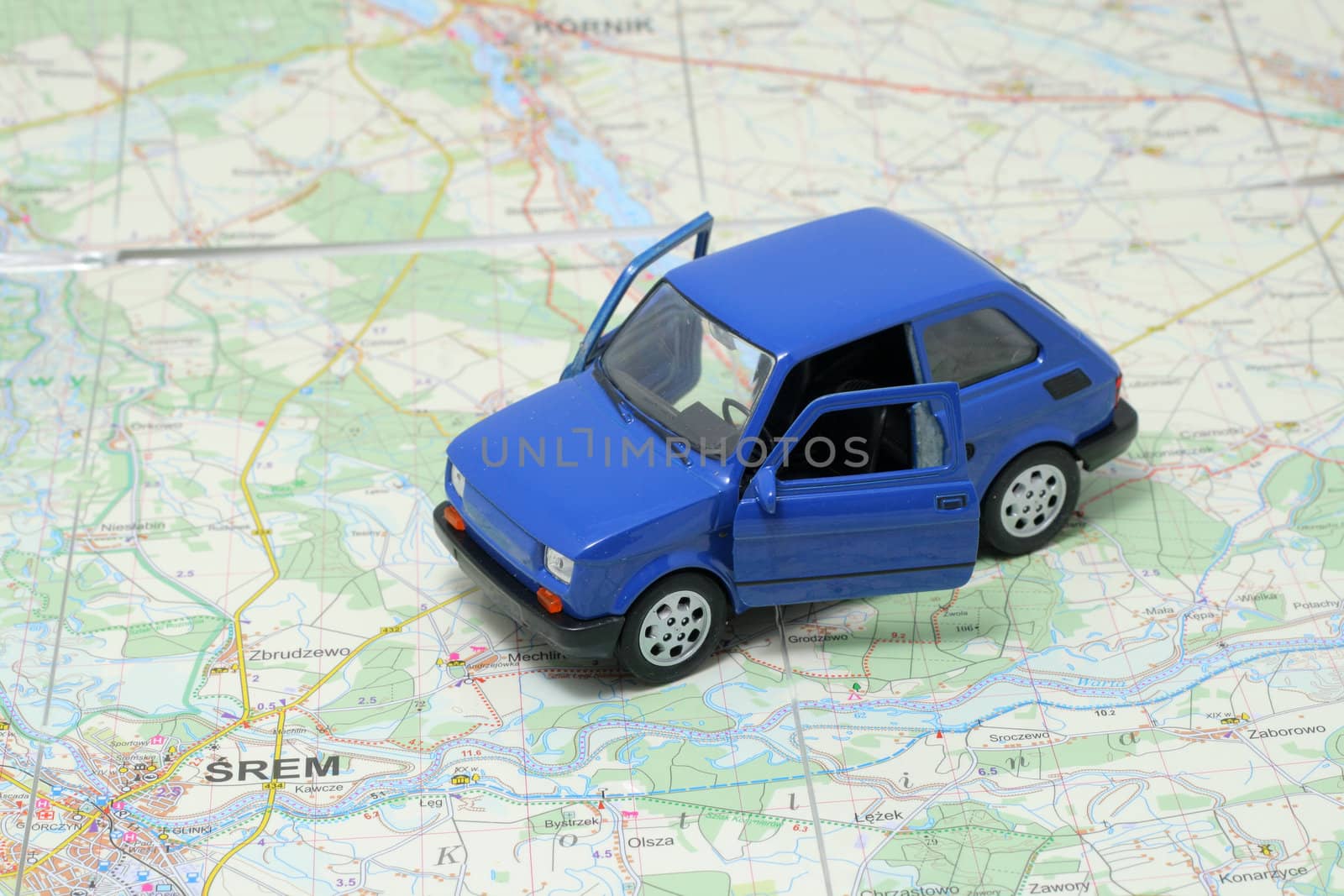 Tiny blue car model on the road map