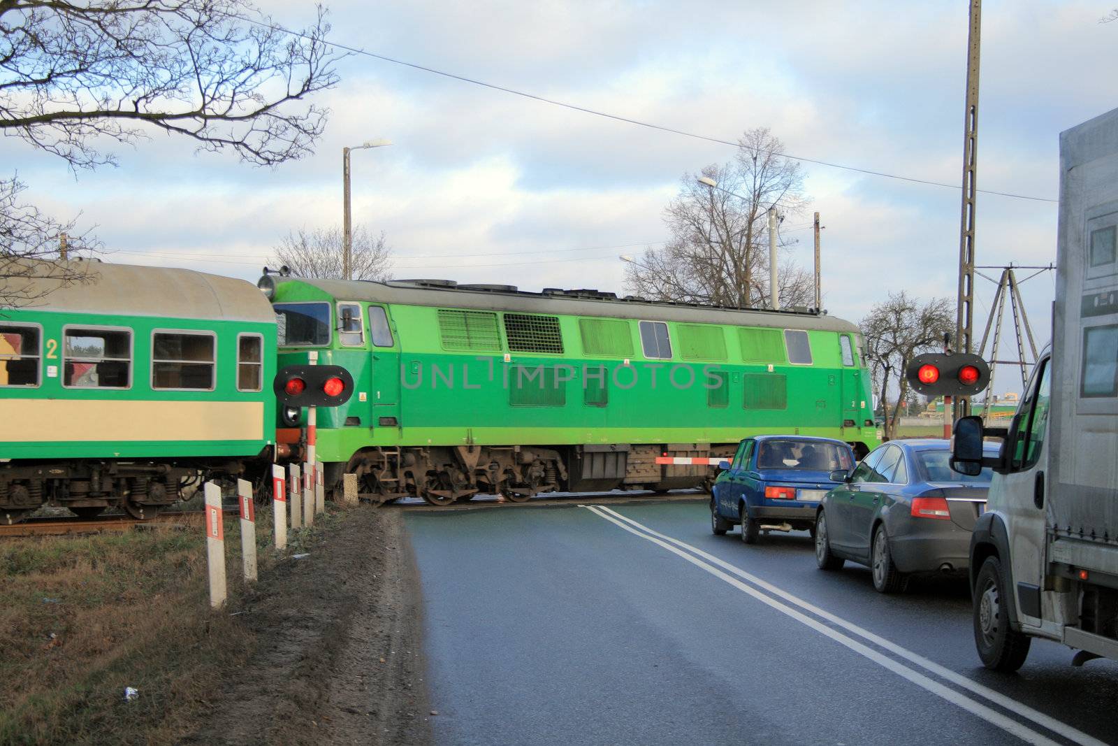 Passenger train passing the railroad crossing with the road