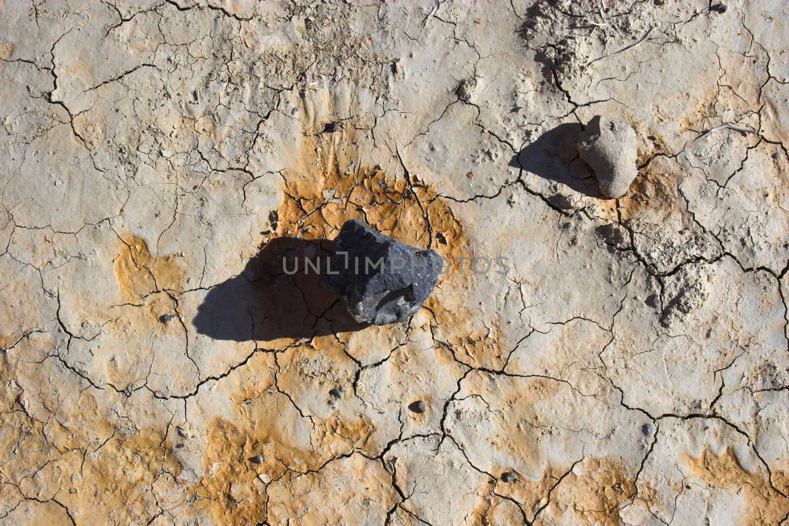 Fragment of black lava and ornage clay and salt mineral deposits in geological formations in Ubehebe Volcano, Death Valley National Park