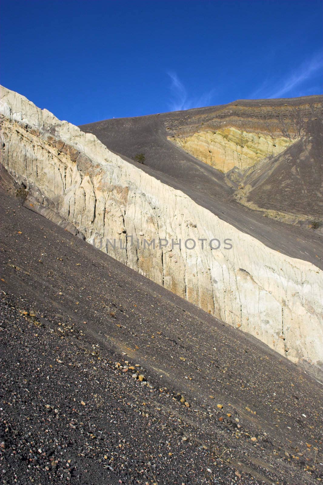 Fragment of black lava and ornage clay and salt mineral deposits in geological formations in Ubehebe Volcano, Death Valley National Park