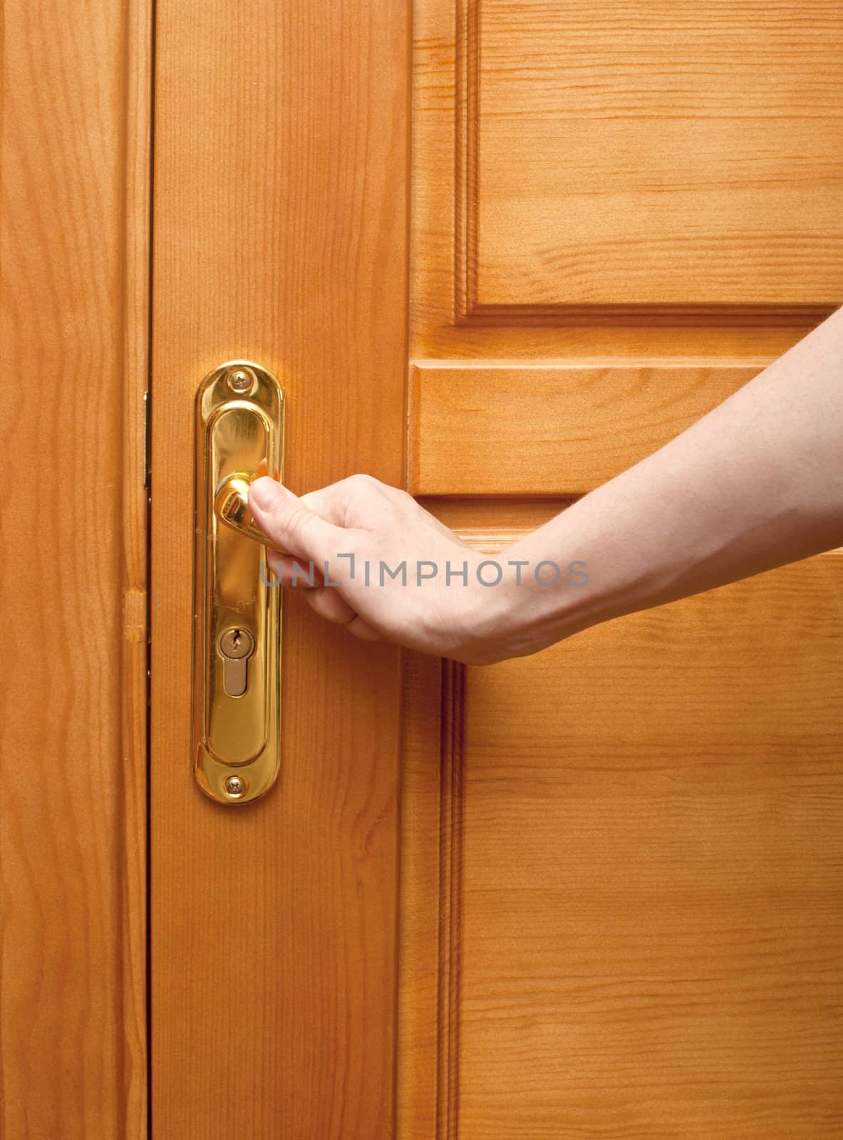 hand on a handle wooden door to open or close it 