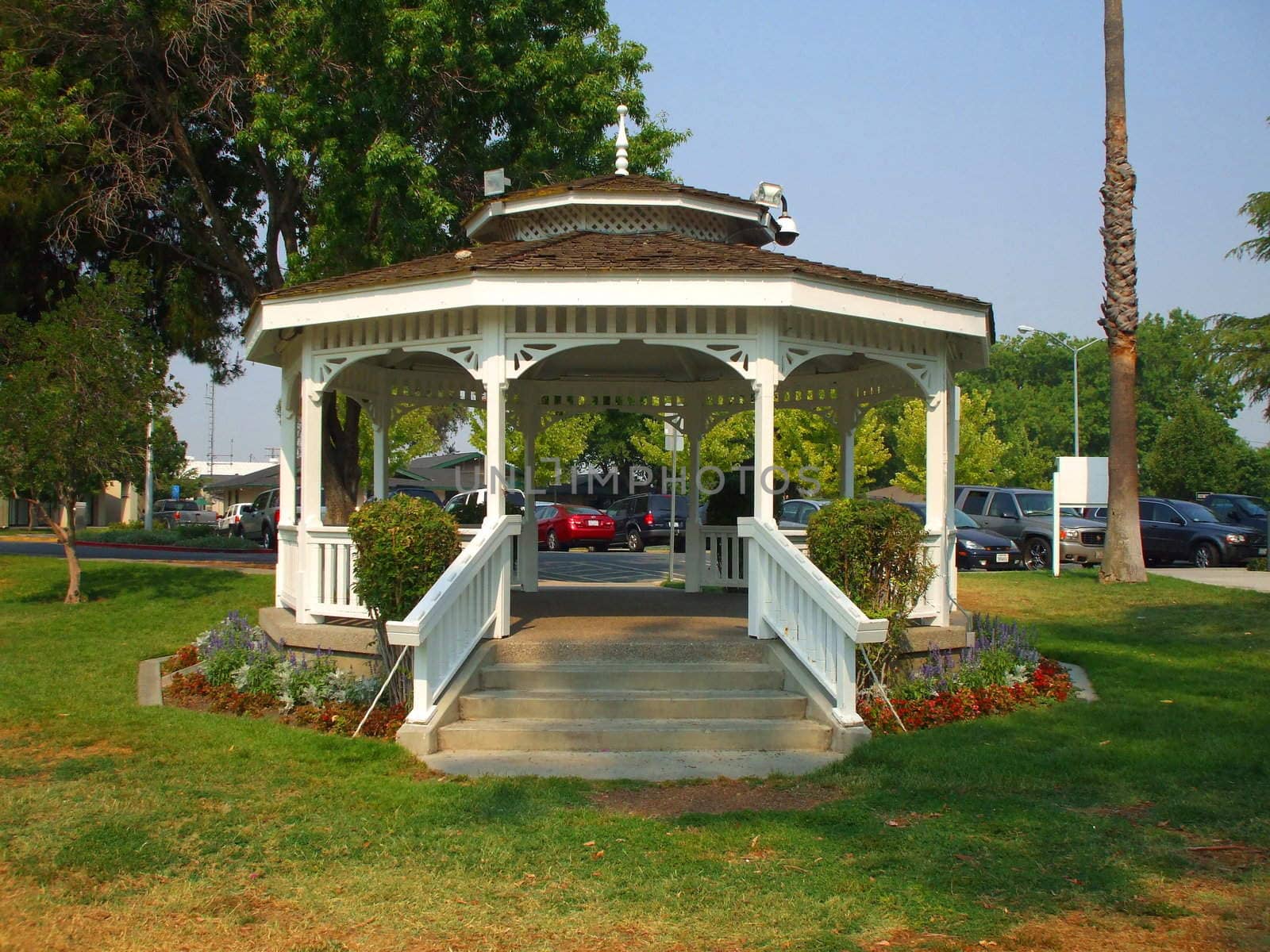 Close up of a white gazebo in a garden.