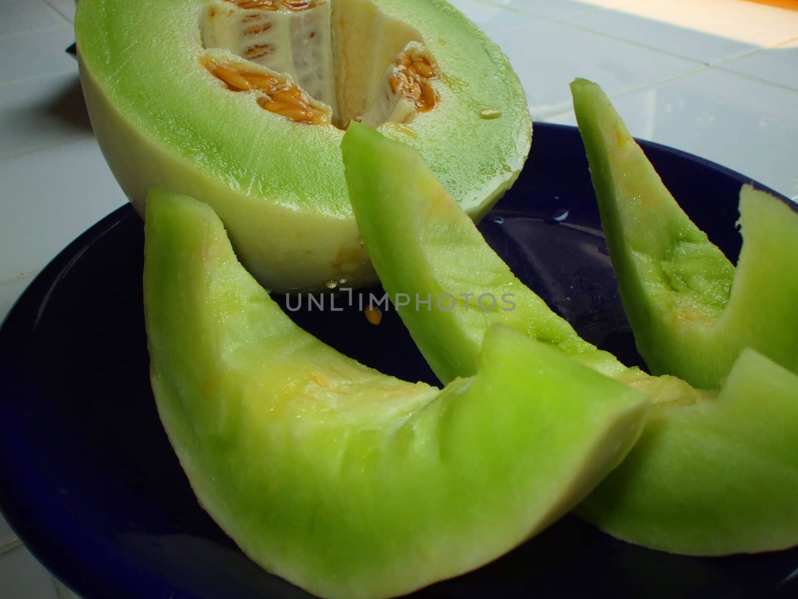 Close up of a honeydew melon on a plate.