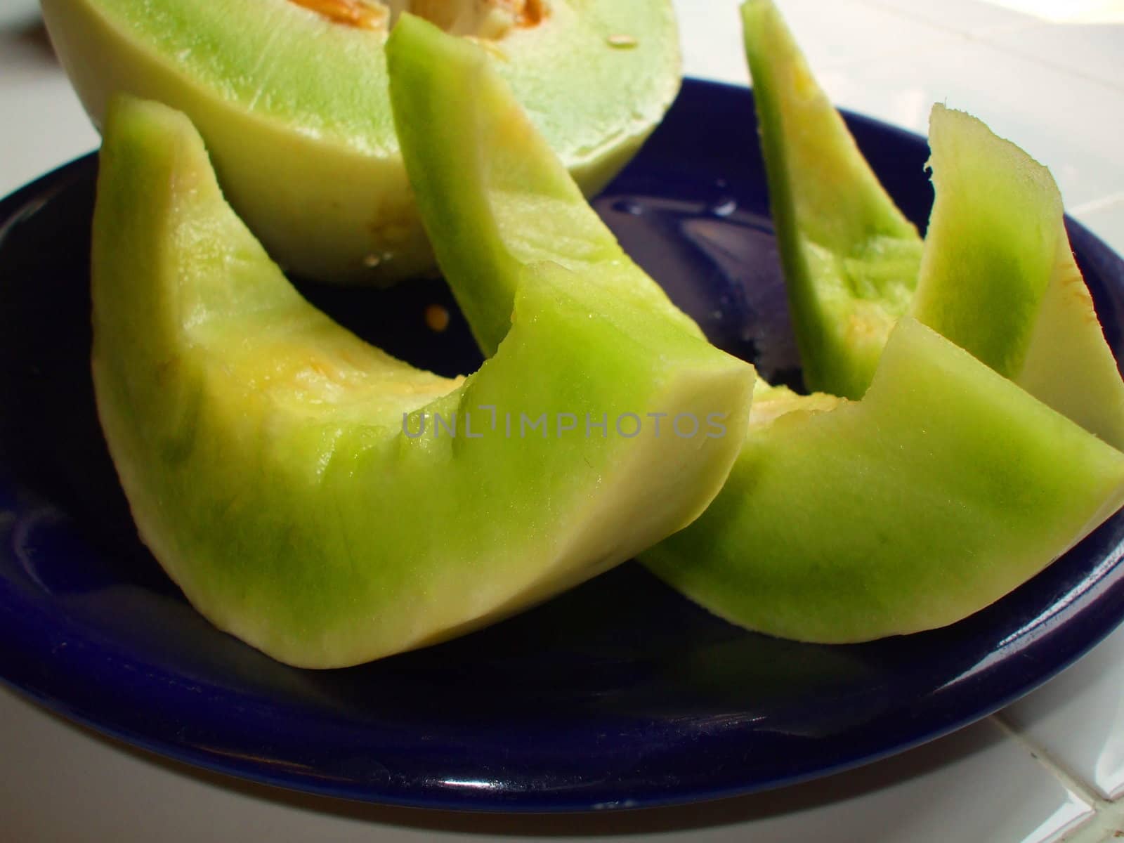 Close up of a honeydew melon on a plate.