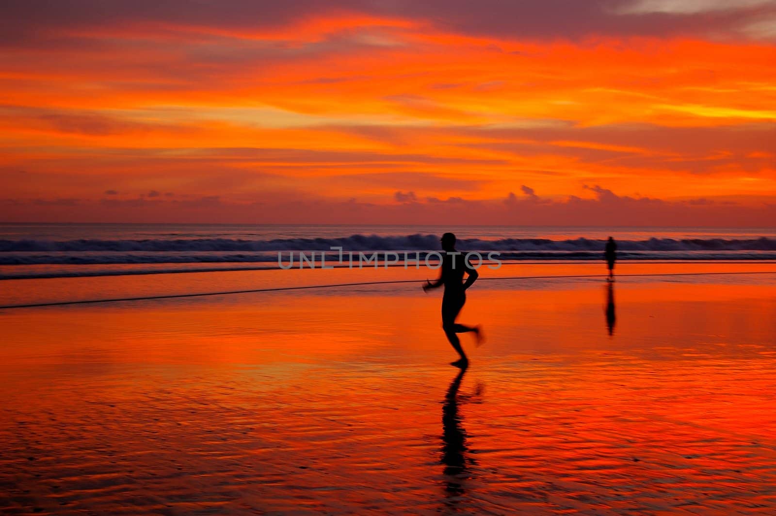Jogging at sunset, on Double Six beach, Bali, Indonesia.