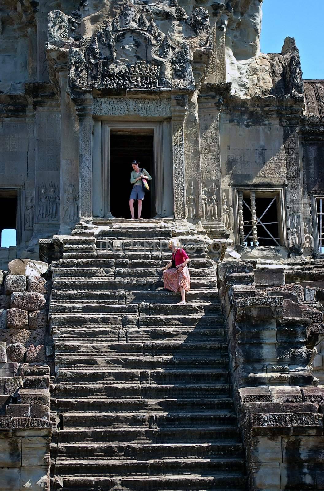 Tourists going down steep steps at Angkor Wat, Siem Reap, Cambodia. Angkor Wat, considered to be one of the Wonders of the World, is one of the most popular destinations in Southeast Asia and extremely important both historically and religiously.