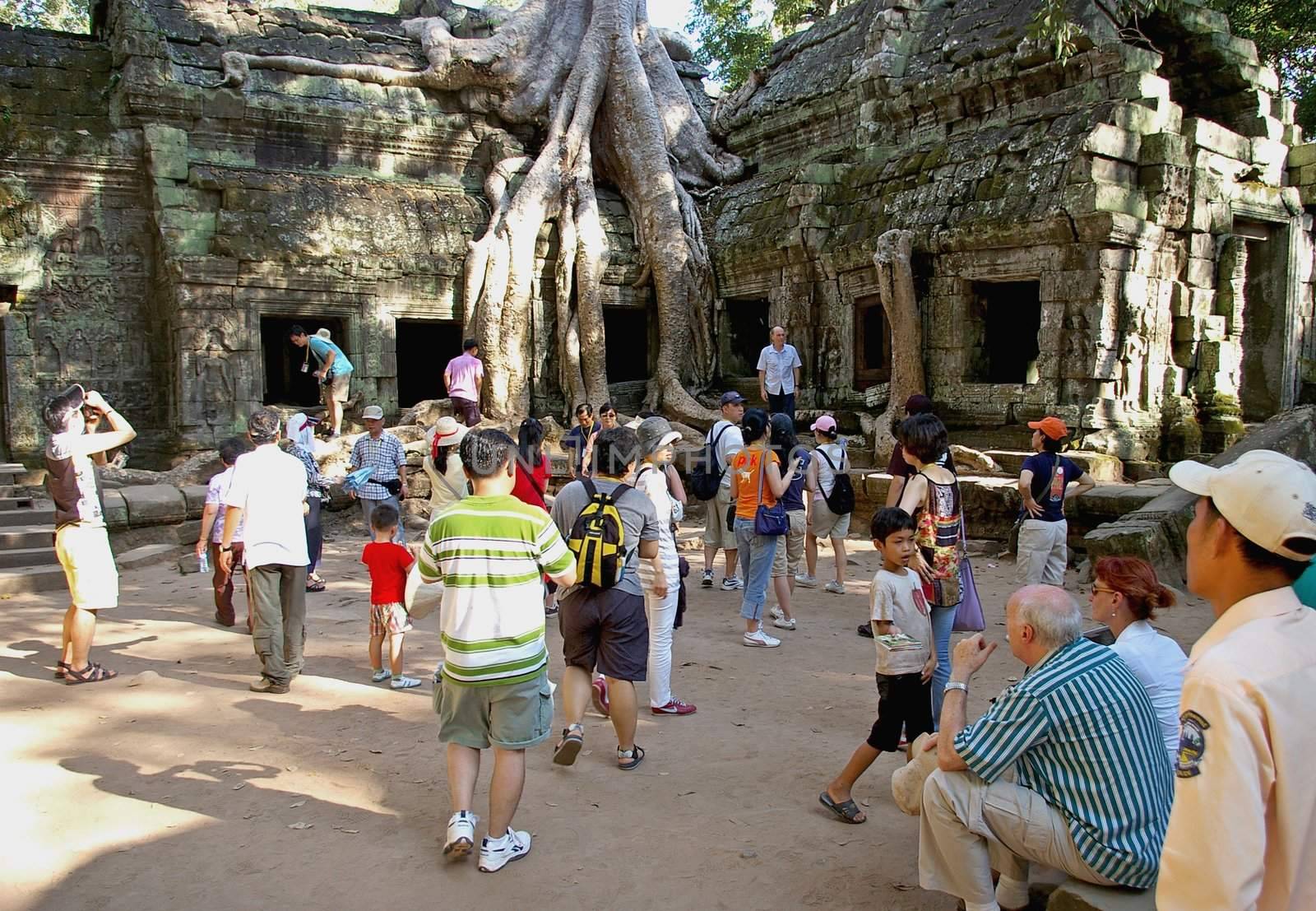 Tourists crowd around part of the famous Bayon temple. This location has been used in various films, such as Indiana Jones and the Temple of Doom and Lara Croft: Tomb Raider. Siem Reap, Cambodia 17.11.09