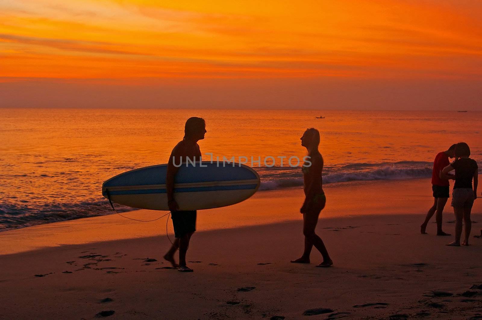 Tourists on the beach at sunset, Dreamland, Bali, Indonesia.
