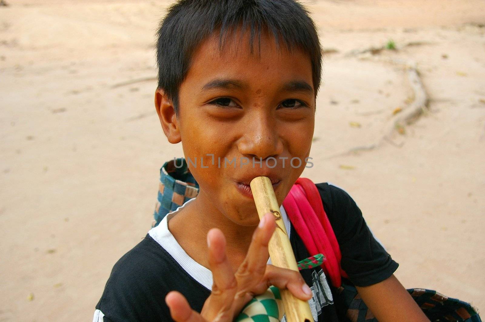 Asian boy playing flute by Komar