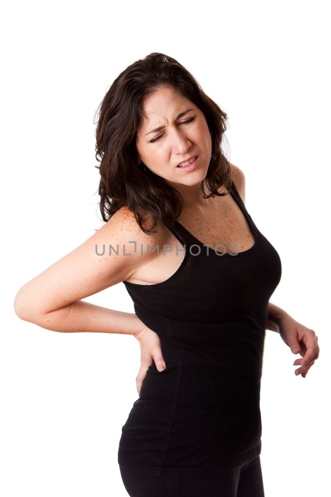 Beautiful woman holding her back with pain and ache due to injury,wearing a sporty black tank top, isolated.