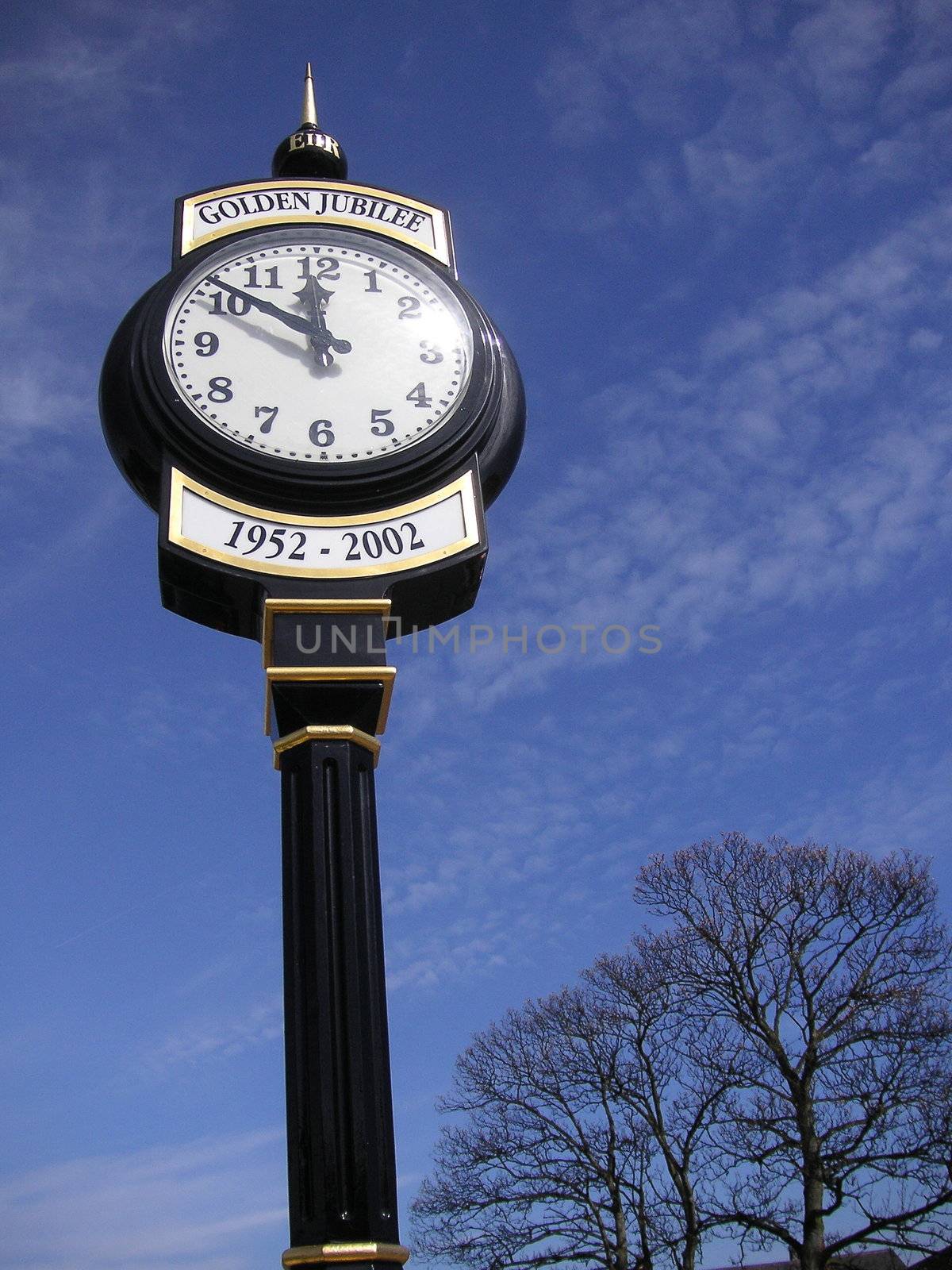 old fashioned style clock against a blue sky
