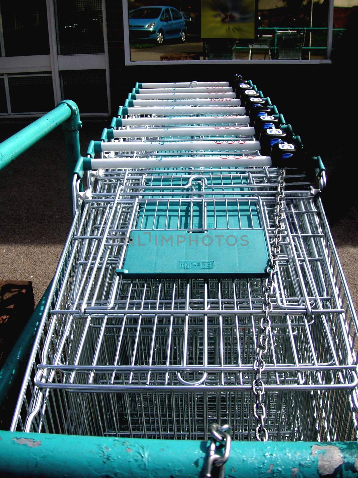 row of shopping trolleys placed outside a supermarket