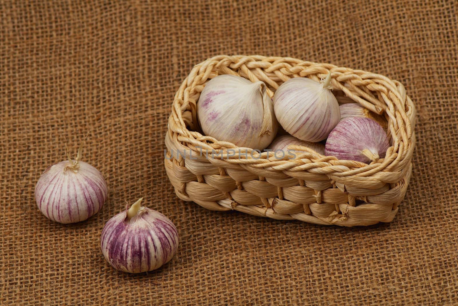 Fresh garlic in a small straw basket. 
