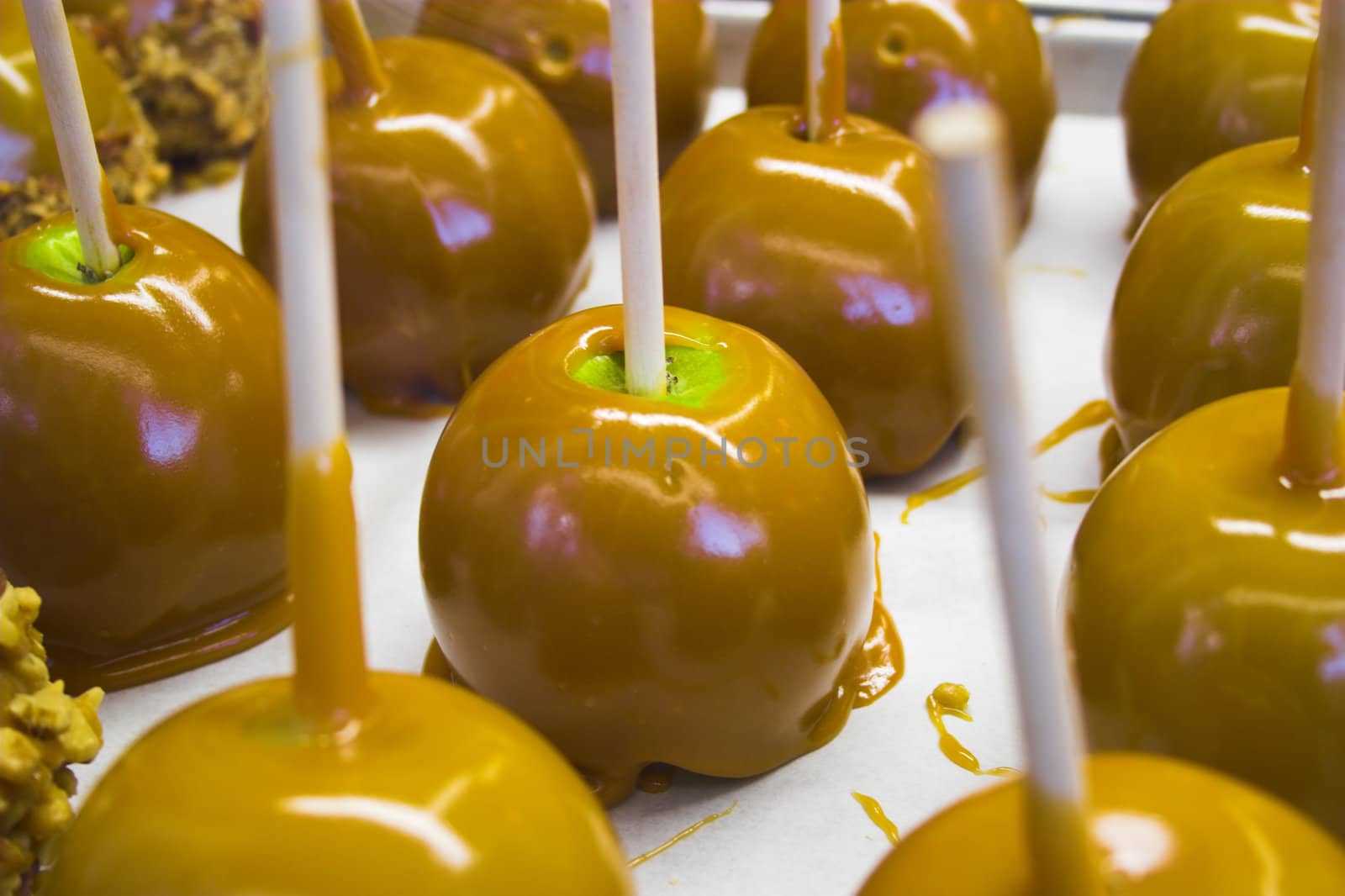 Green apples on food tray covered with sweet caramel