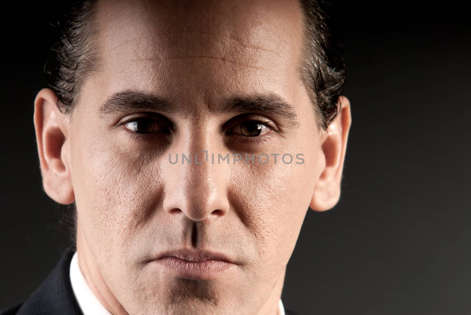 Adult businessman closeup portrait on dark background. by dgmata