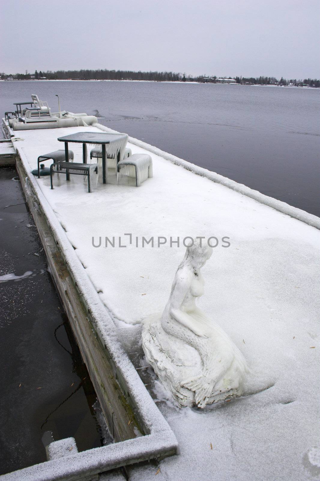 Lonely winter pier over partially frozen lake